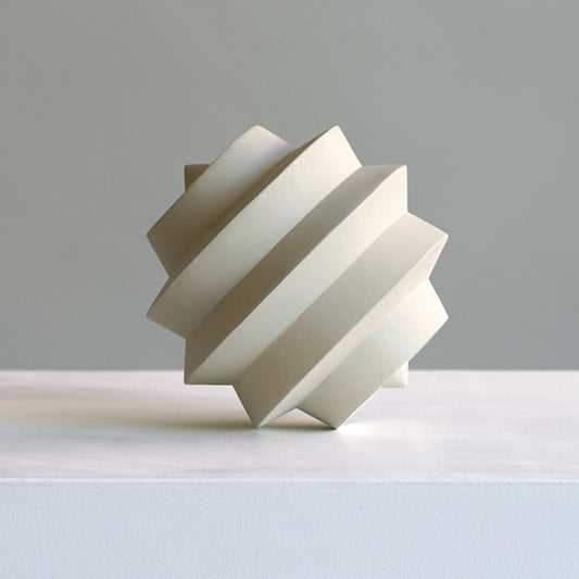 Modern geometric sculpture on a light grey background