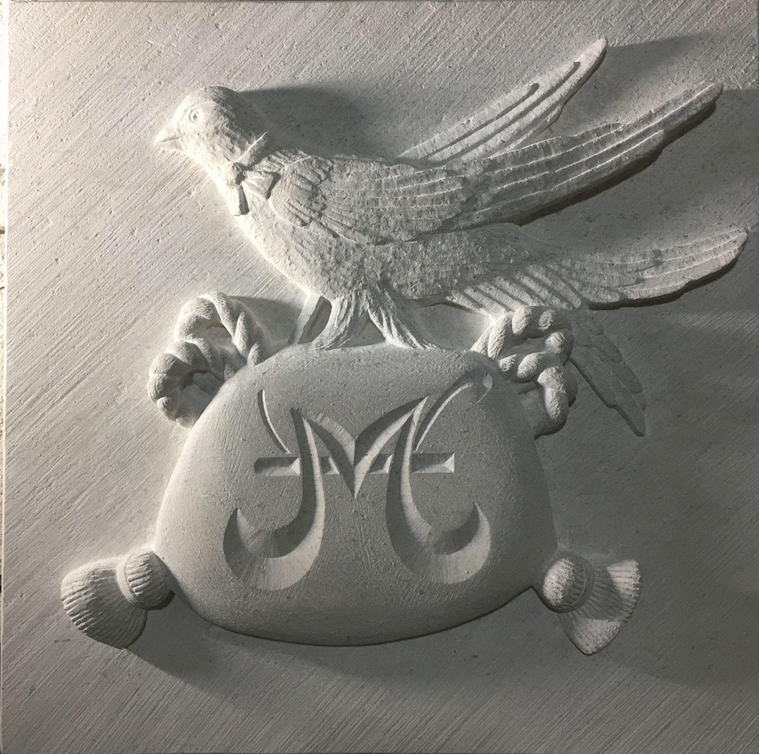 Family crest of a Martlet on top of a purse carved in stone