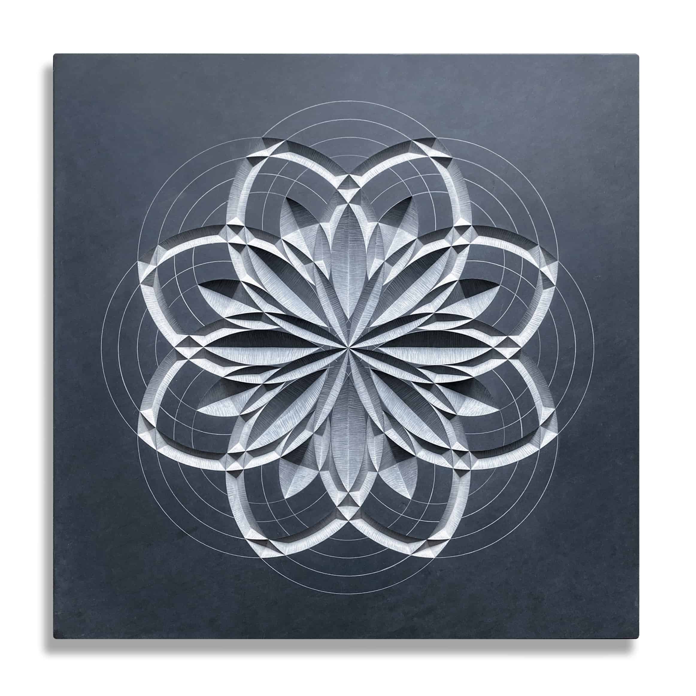 Geometric pattern which looks a little like a flower carved into dark grey welsh slate