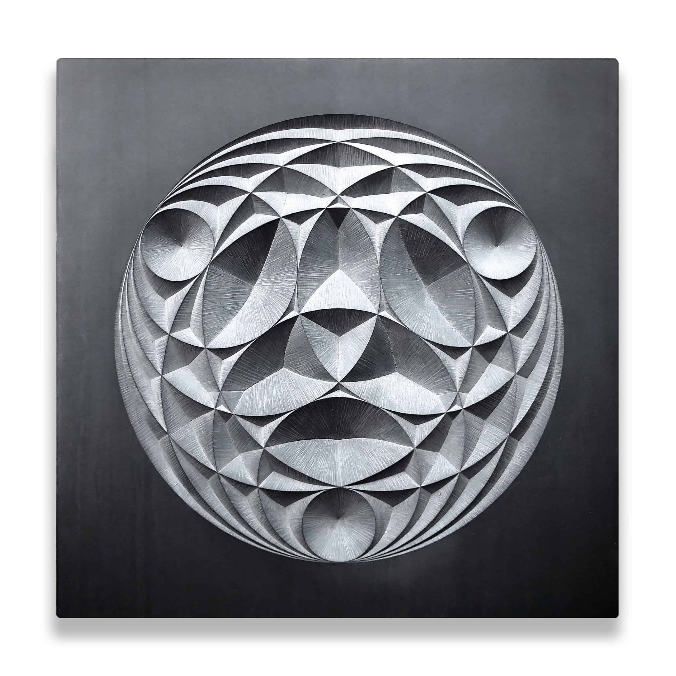 circular geometric pattern carved into smooth dark grey welsh slate