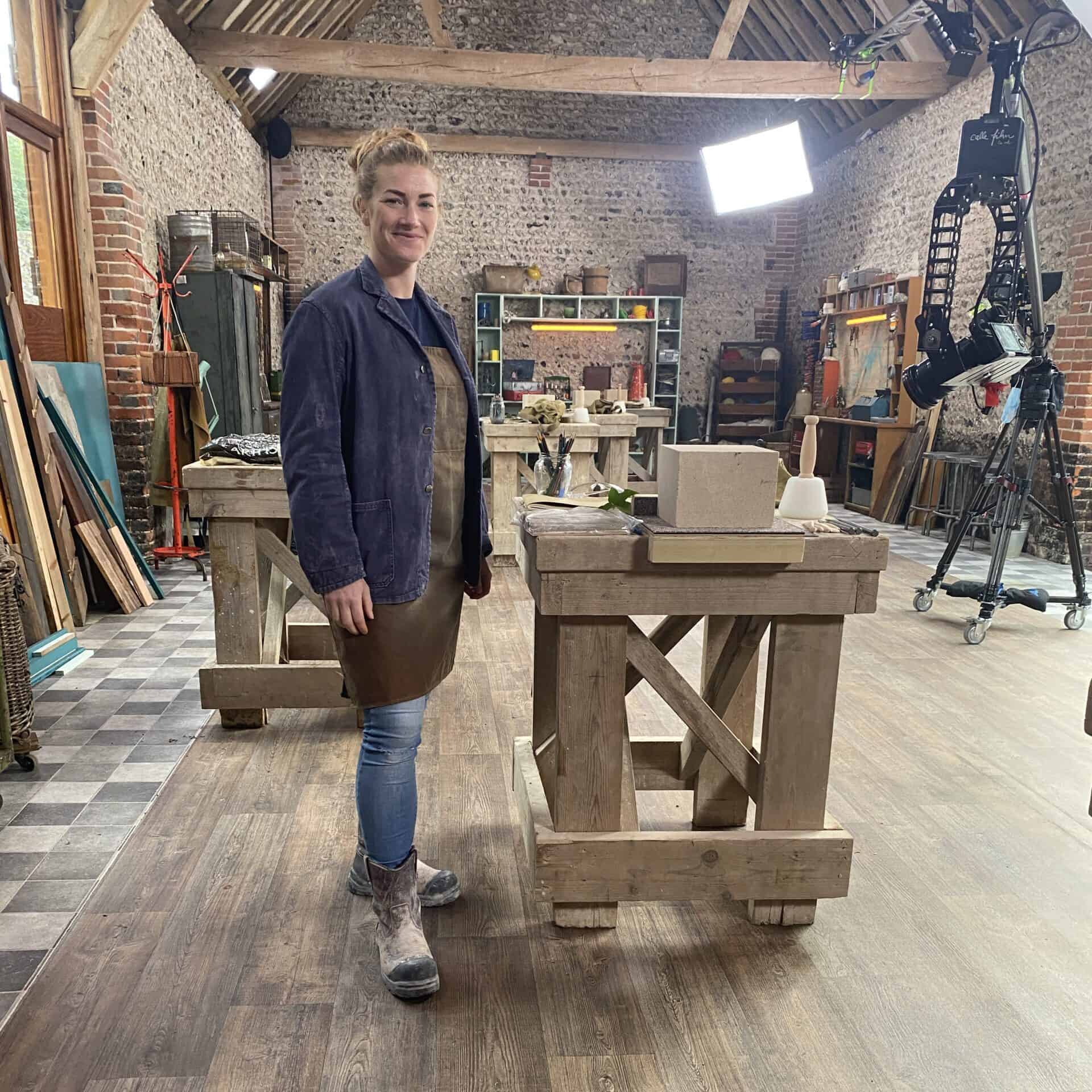 Zoe Standing on a film set next to a workbench with a light in the background